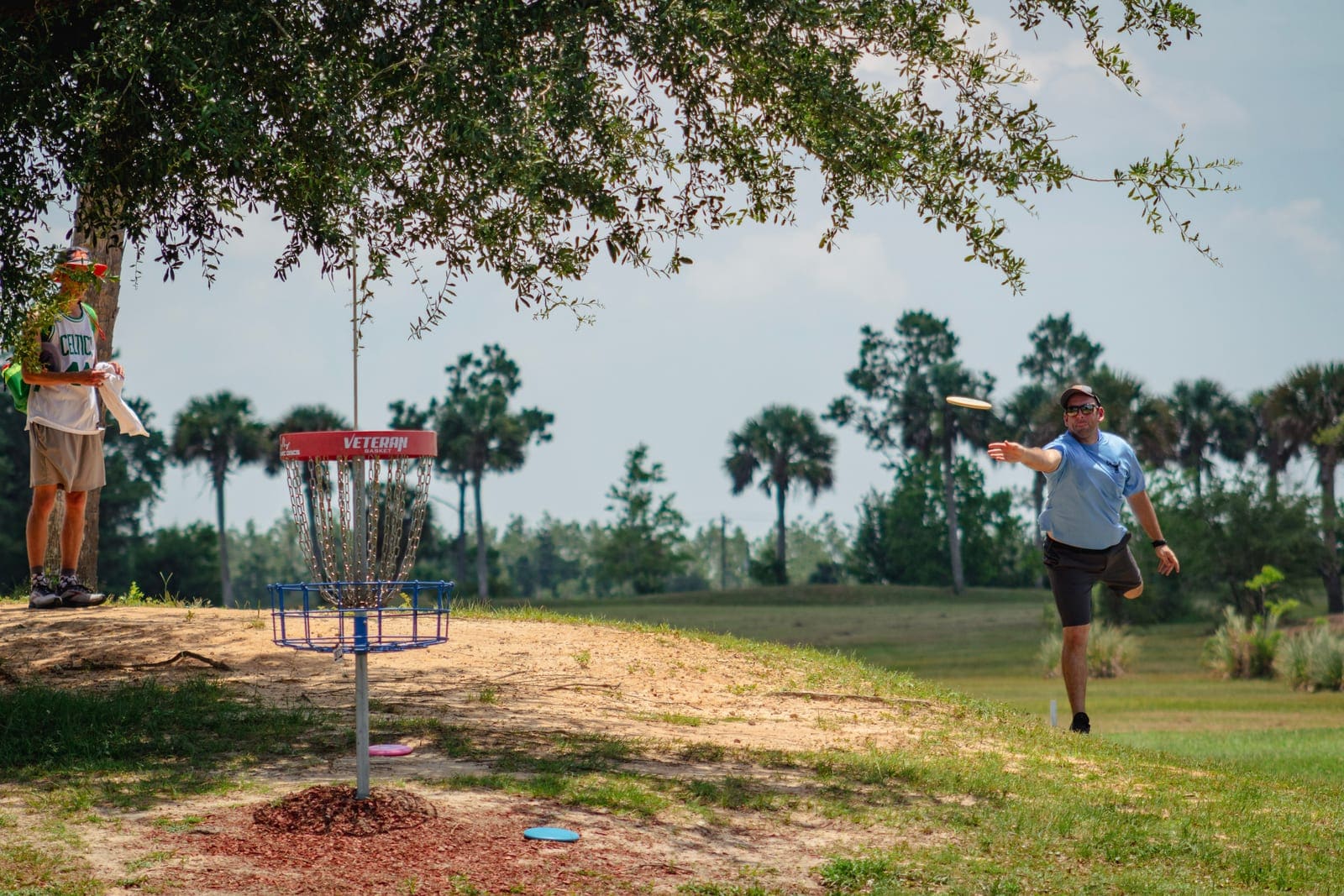 A basket standing on open ground at Majette, palms and scrub behind it and nobody in the frame.